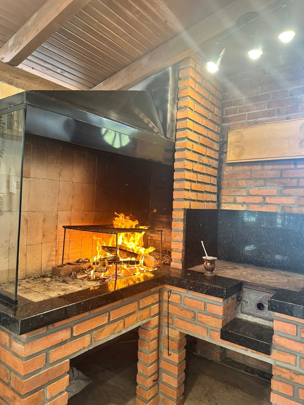 Lareira interna acesa em alvenaria de tijolos