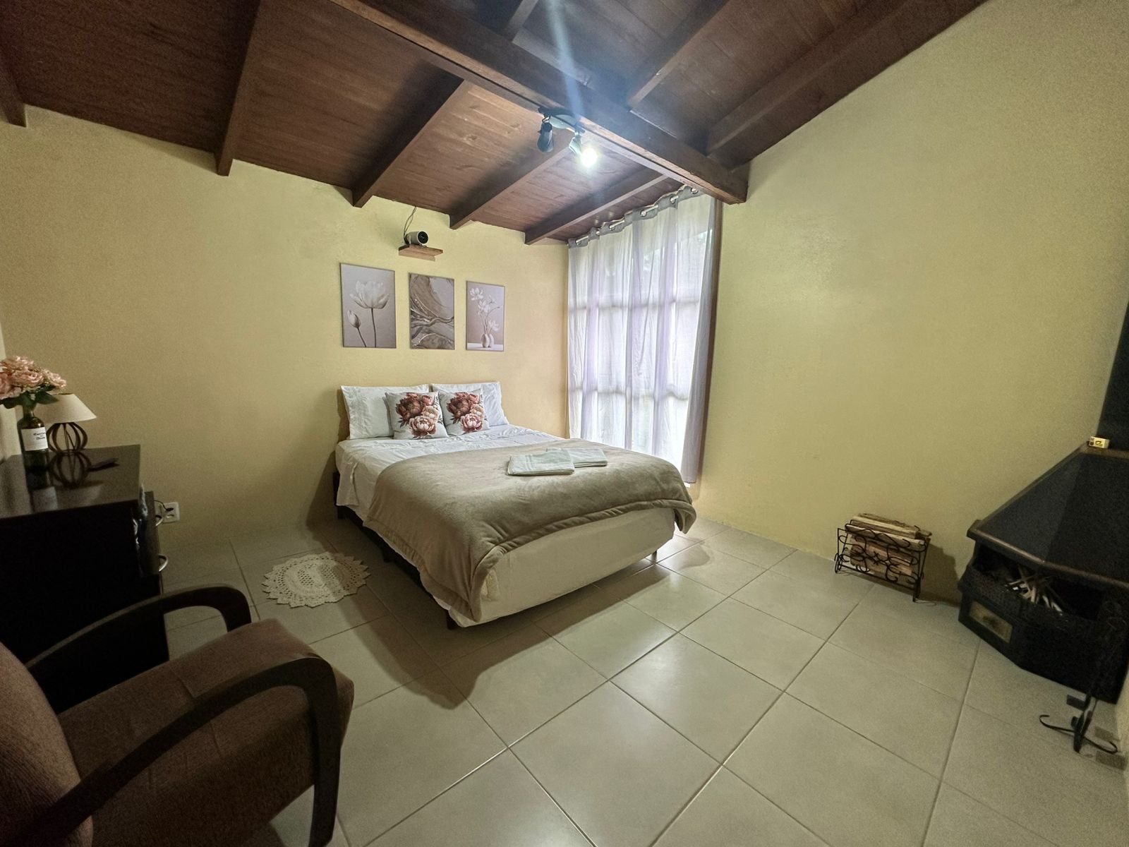 Quarto com cama de casal e roupa de cama clara
