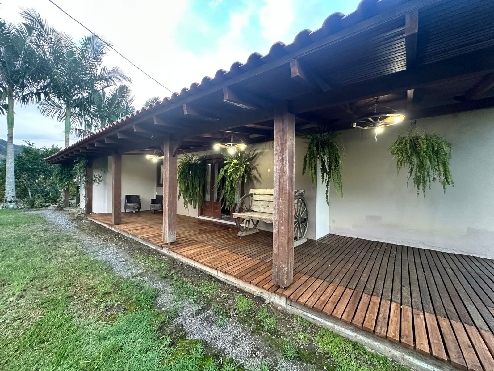 Varanda de madeira da casa cercada por natureza